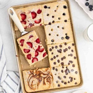 Sheet pan pancakes topped with strawberries, blueberries, chocolate chips and cinnamon swirl.