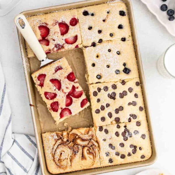 Sheet pan pancakes topped with strawberries, blueberries, chocolate chips and cinnamon swirl.