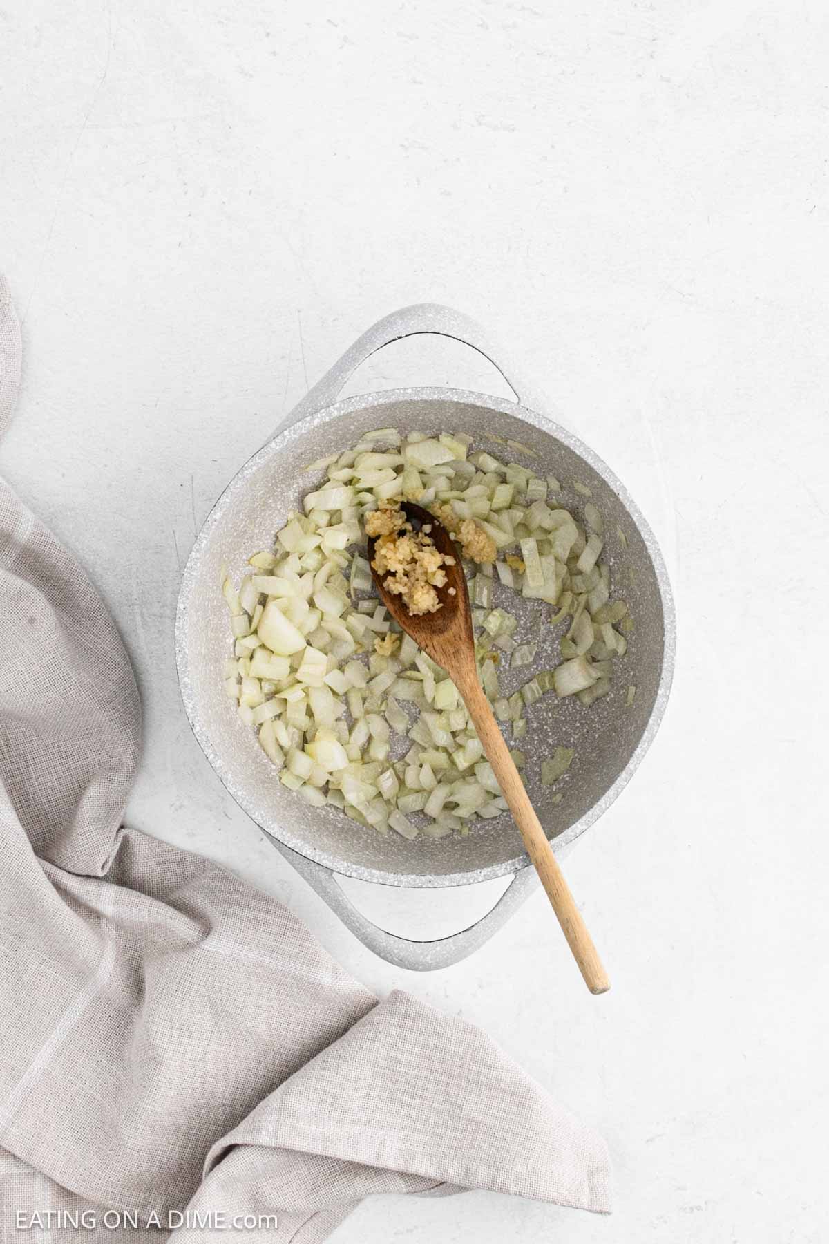 Roasted diced onion in a large pot with minced garlic.