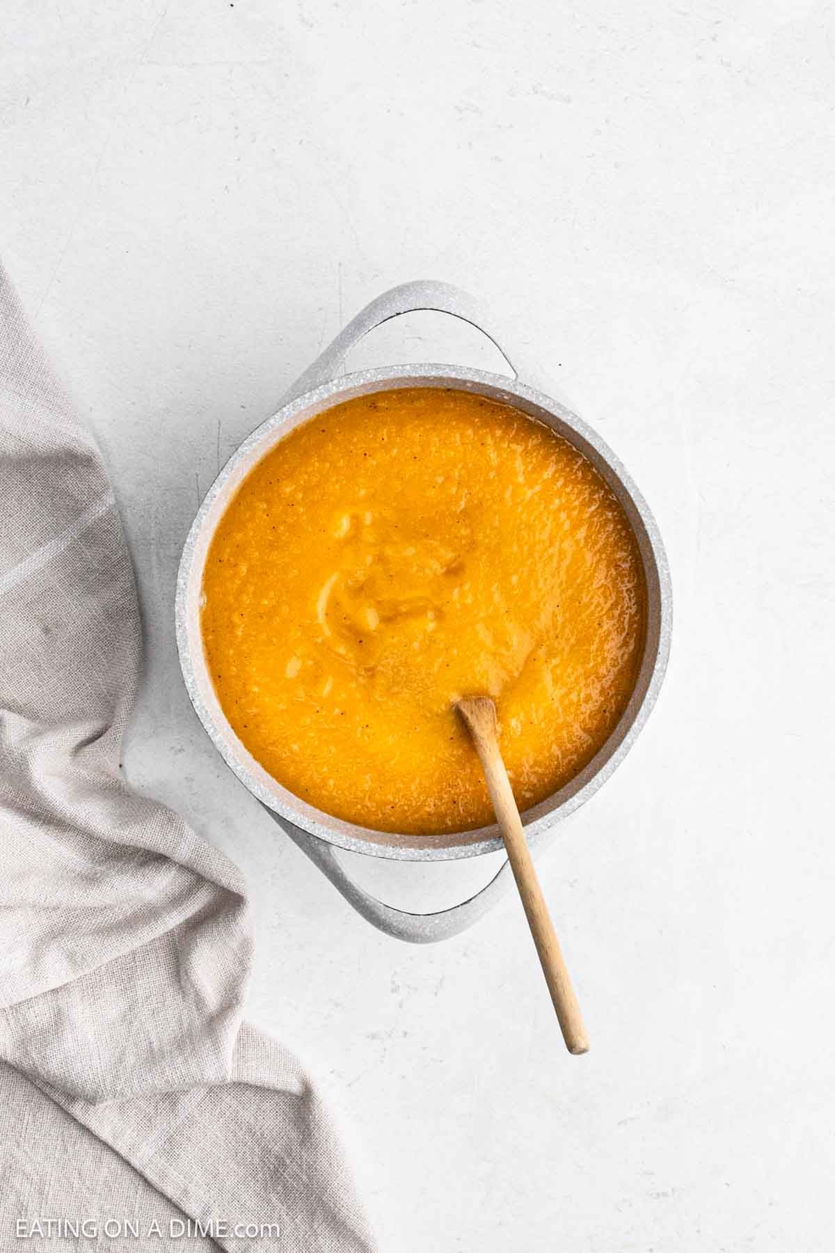Soup in a large pot with wooden spoon.