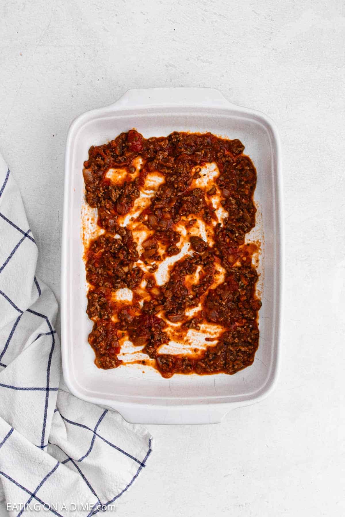 Meat sauce spread in a baking dish.