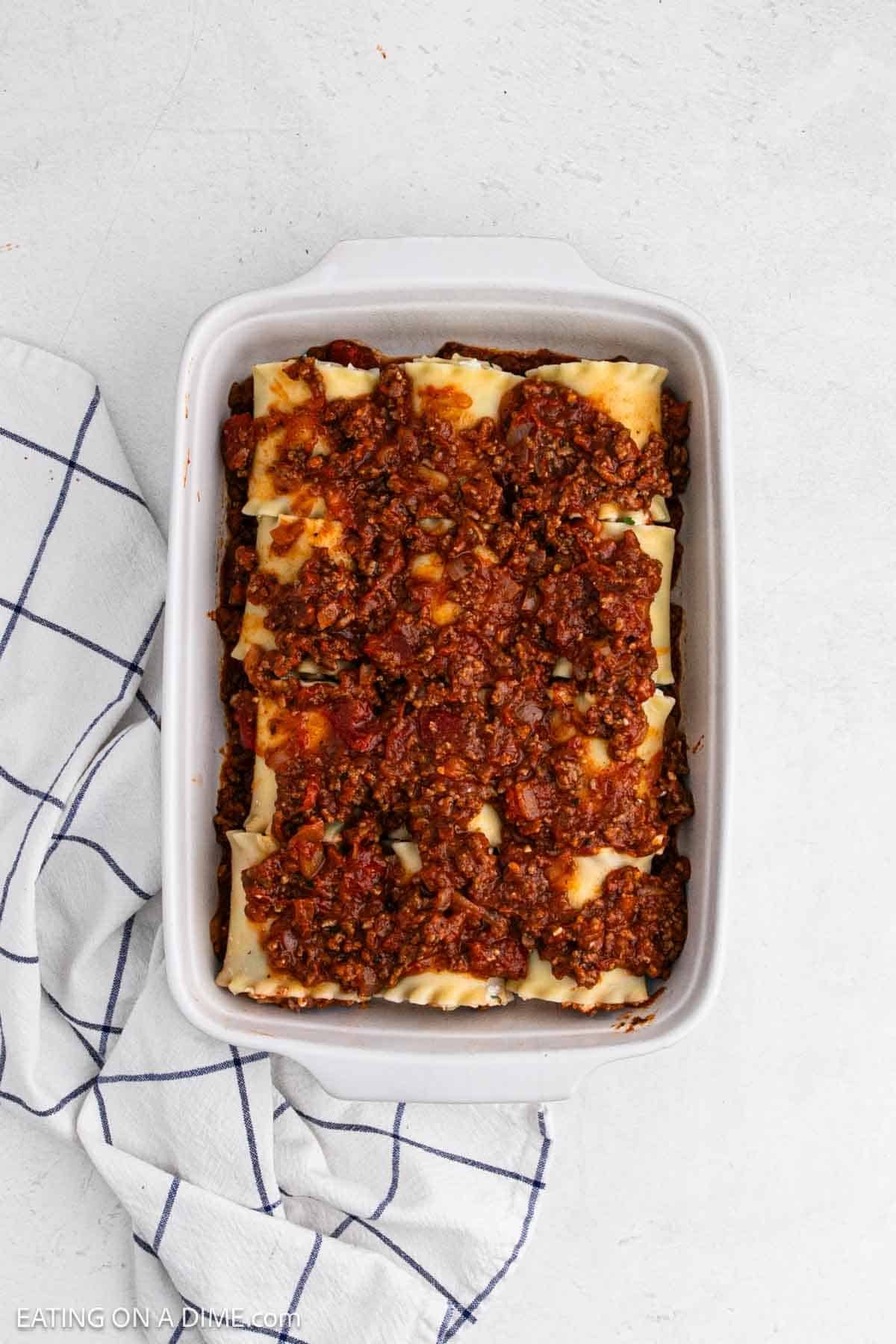 Meat sauce topped the rolled lasagna noodles in the baking dish.
