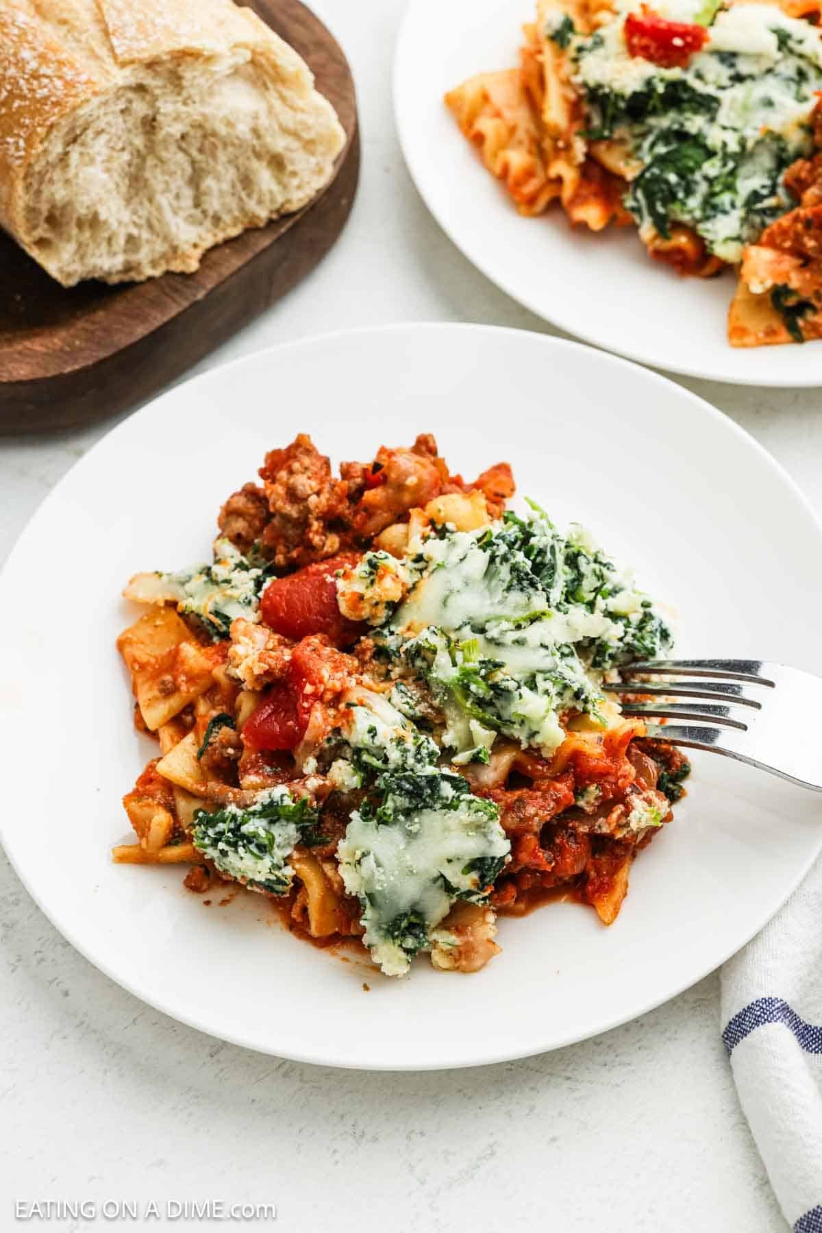 A serving of lasagna topped with spinach ricotta cheese on a plate.