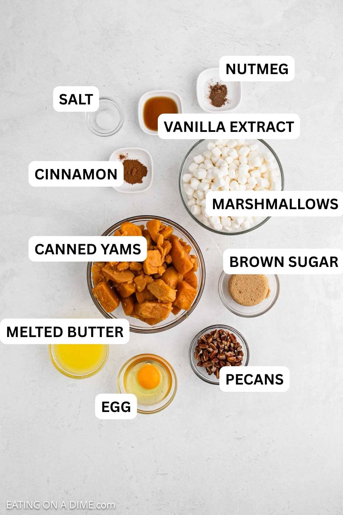 Ingredients needed for this recipe include canned yams, butter, brown sugar, egg, vanilla extract, cinnamon, nutmeg, salt, marshmallows, and pecans.