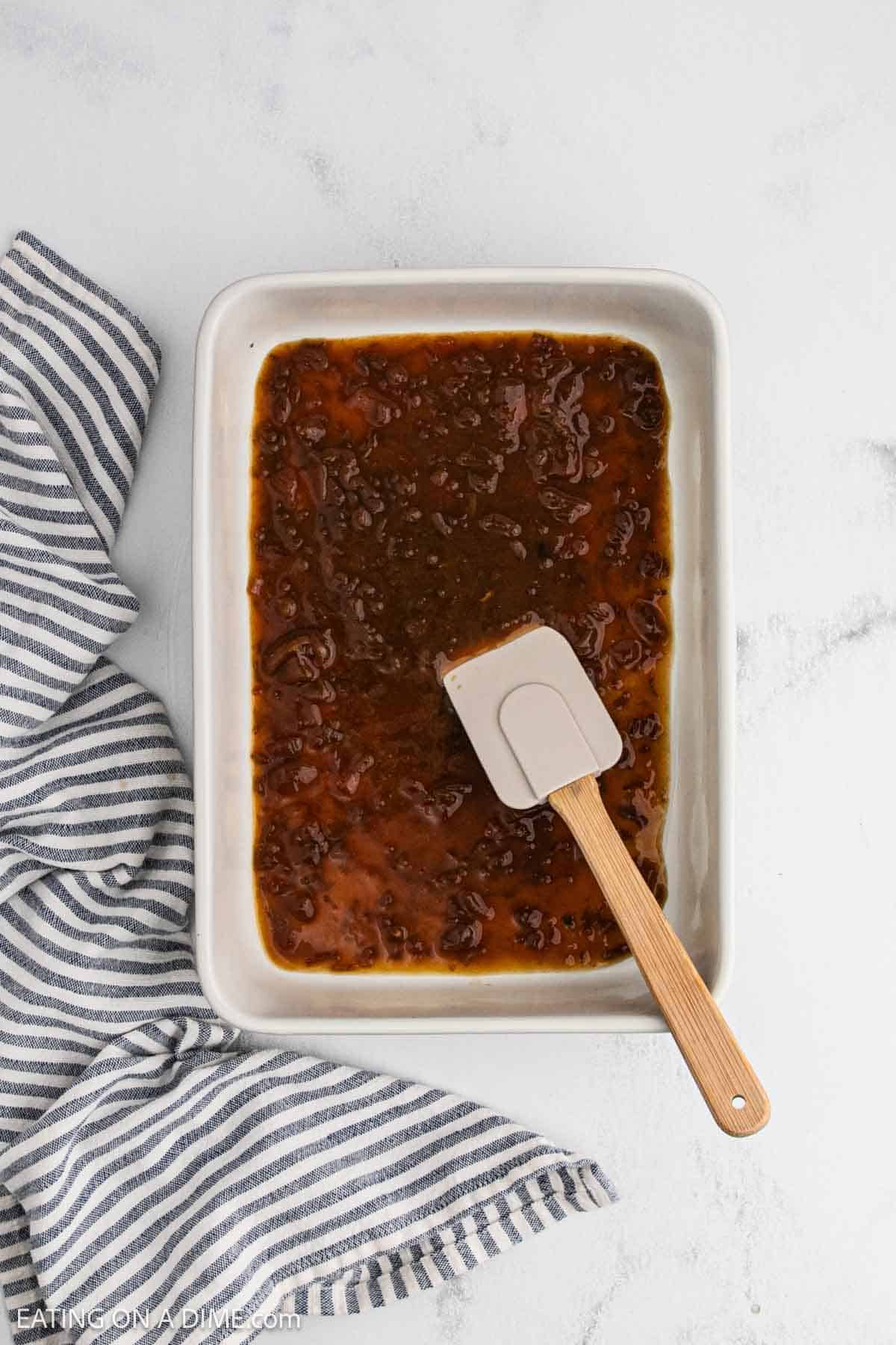 French onion soup spread into the baking dish with spatula.