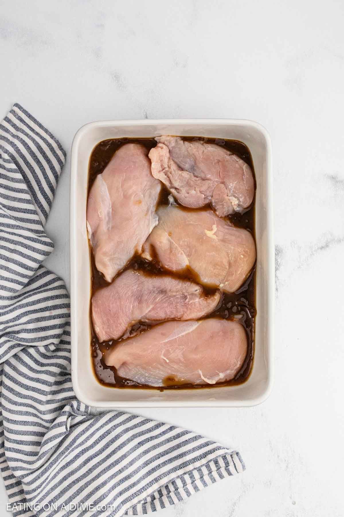Chicken breasts placed in the baking dish on top of French onion soup.