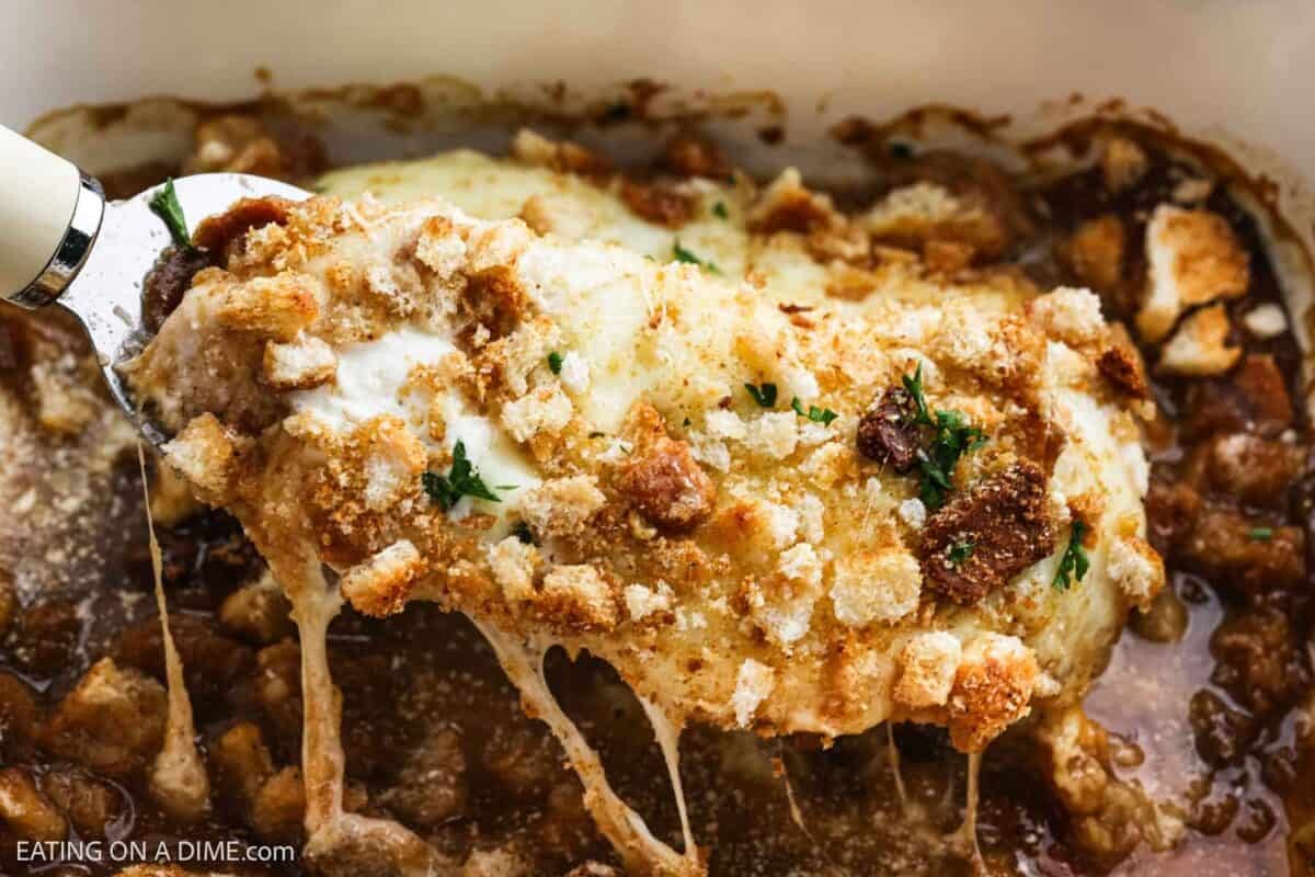 Close up image of French Onion Chicken Bake on a spatula ready to serve from the baking dish.